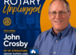 Poster for Grand Rapids Rotary Unplugged featuring John Crosby, VP of Operations, with city skyline in blue and yellow design.