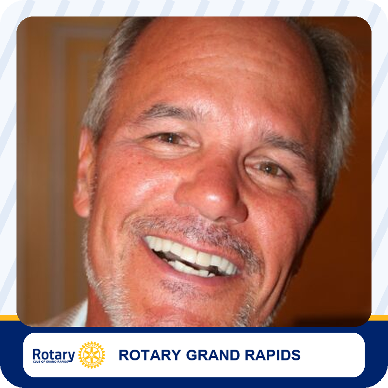 Close-up portrait of a smiling middle-aged man with gray hair, used for Rotary Grand Rapids.
